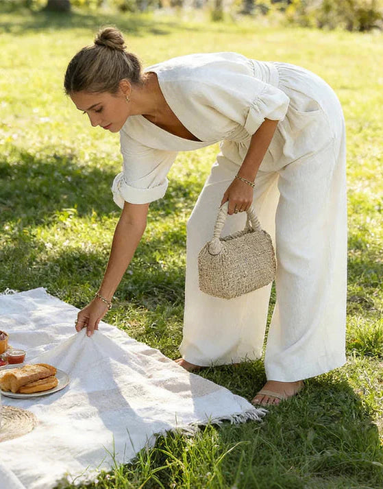 Combinaison élégante Daniela de Danoir Paris en blanc, avec décolleté en V et jambes larges, portée par un mannequin.