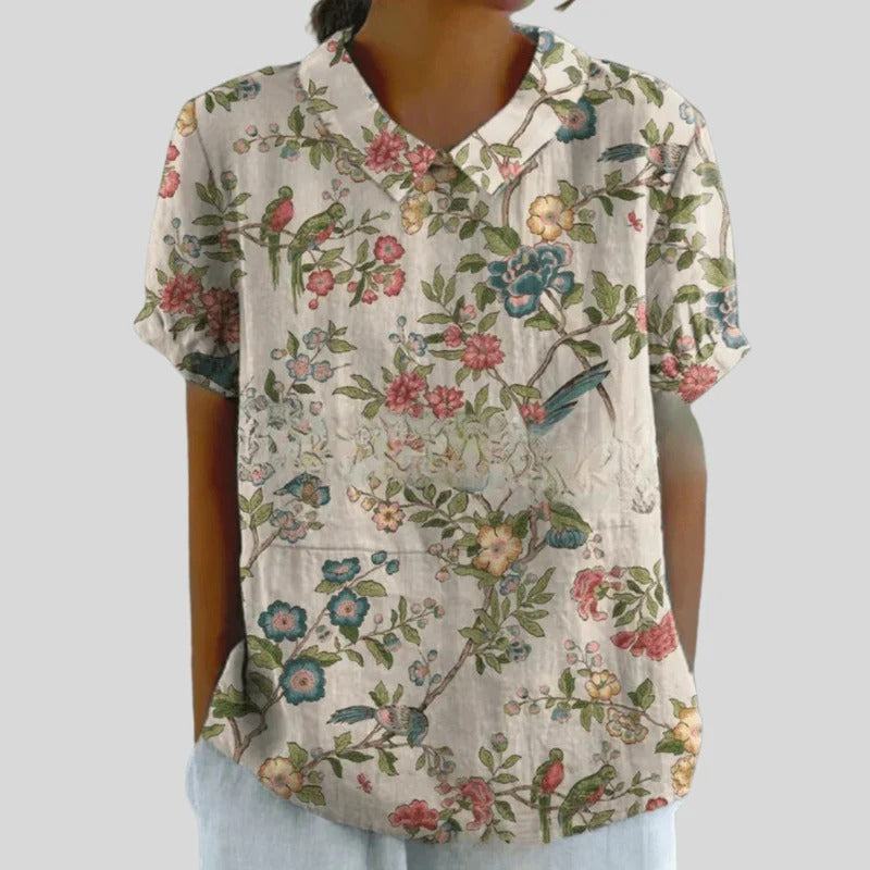 Blouse Clarélia™ de Danoir Paris avec motifs floraux délicats, tissu blanc léger et style élégant.