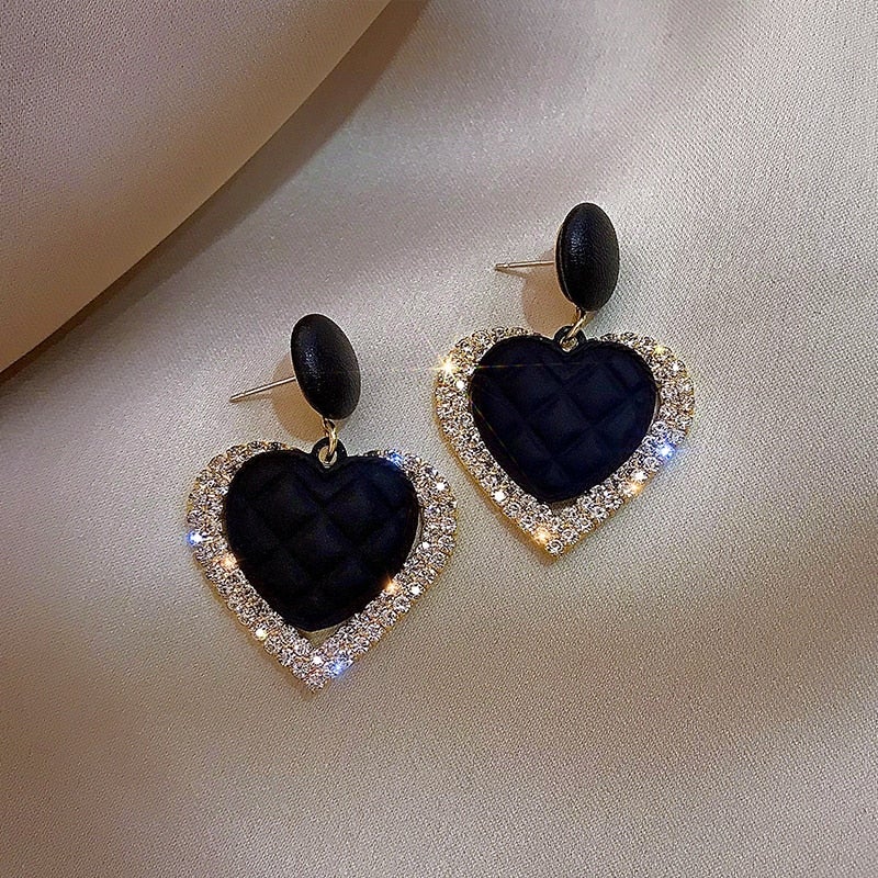 Boucles d'oreilles en or noir en forme de cœur, bijoux élégants de Danoir Paris, visibles avec détails raffinés.