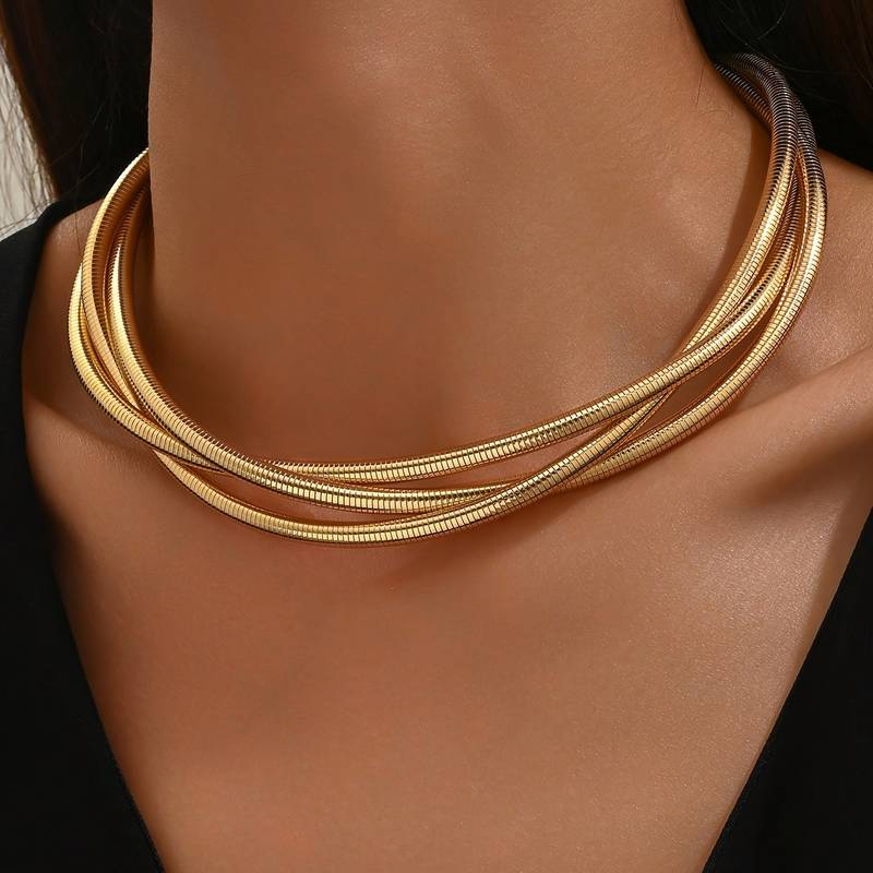 Collier doré vintage à couches Danoir Paris avec pendentifs délicats et détails élégants, porté sur un fond neutre.