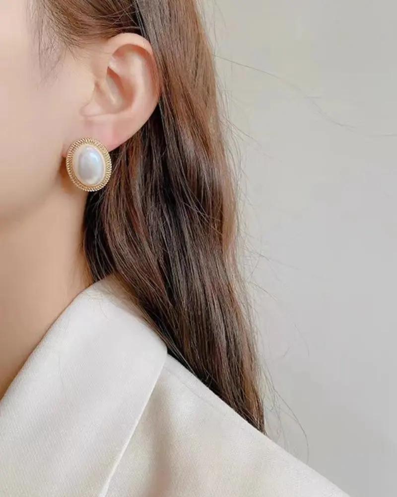 Boucles d'oreilles Danoir Paris Radiance en perles ovales, élégantes et sophistiquées, visibles sur fond clair.