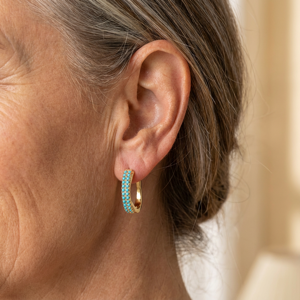 Boucles d'oreilles créoles classiques turquoise Danoir Paris, en métal orné de pierres turquoise brillantes.