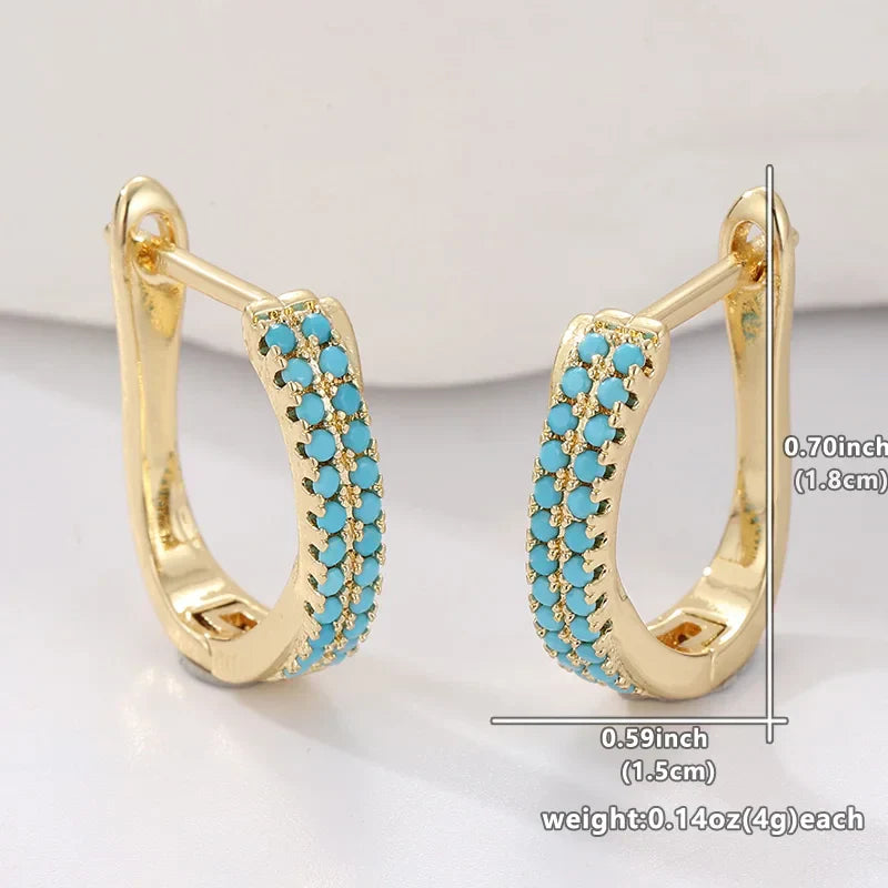 Boucles d'oreilles créoles classiques turquoise Danoir Paris, en métal brillant, visibles en gros plan.