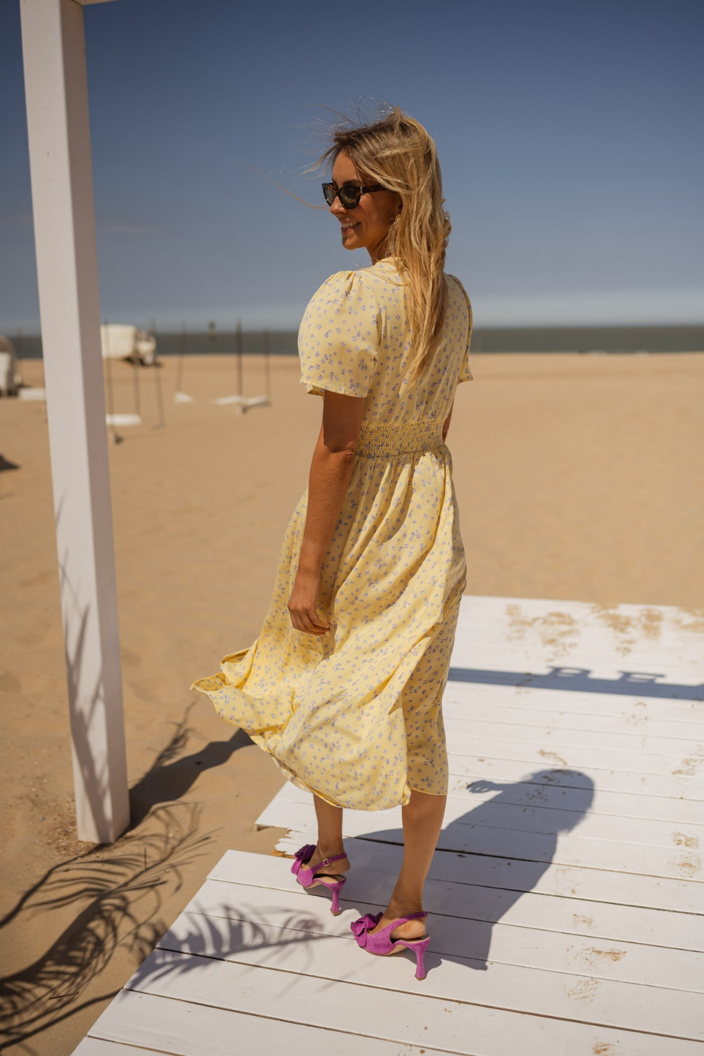 Robe midi éclairante rose Danoir Paris Liva, élégante et fluide, portée avec détails visibles sur le tissu et la coupe.