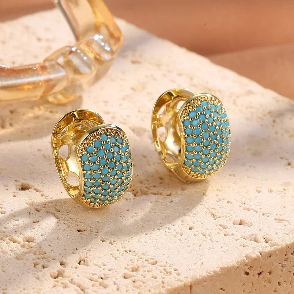 Boucles d'oreilles créoles épaisses en turquoise de la marque Danoir Paris, visibles en gros plan.