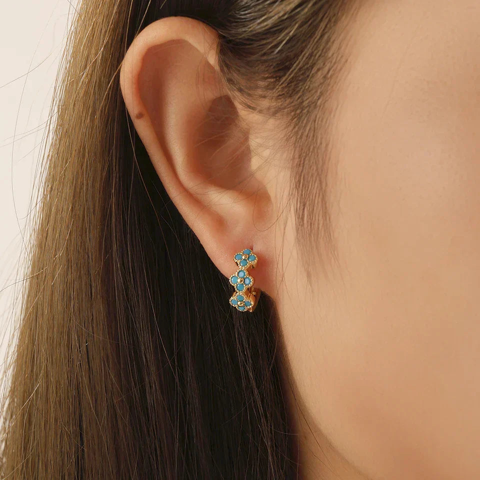 Boucles d'oreilles créoles Danoir Paris avec pendentifs en forme de fleurs turquoise, élégantes et légères.
