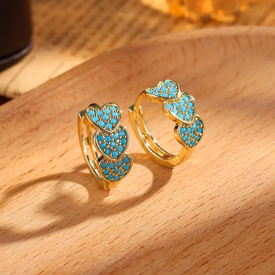 Boucles d'oreilles créoles en forme de cœur turquoise de Danoir Paris, bijoux élégants en métal.