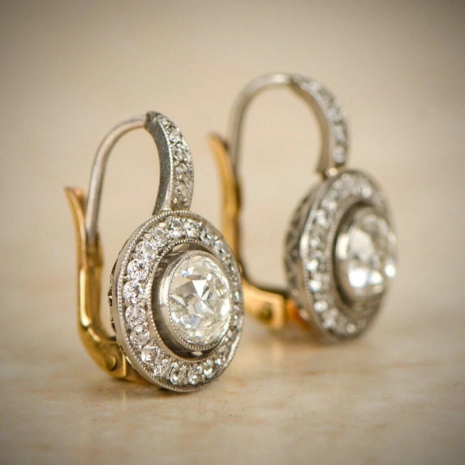 Boucles d'oreilles vintage en or et argent avec cristaux, de la marque Danoir Paris, visibles en détails dans cette image.