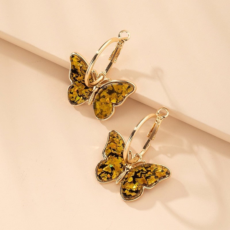 Boucles d'oreilles créoles dorées avec papillons multicolores, bijoux élégants de Danoir Paris.