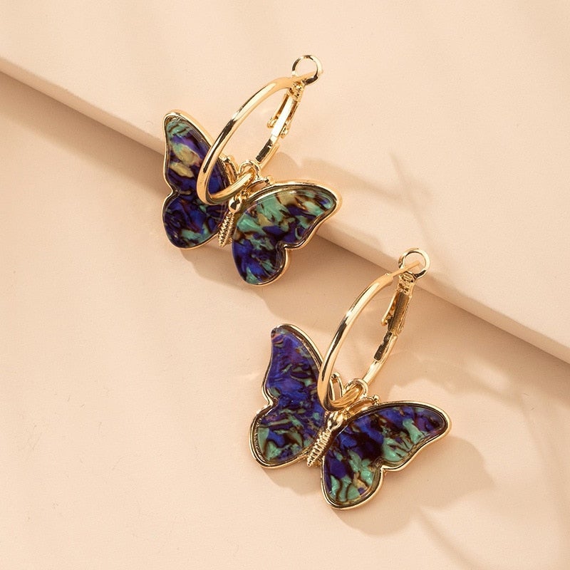 Boucles d'oreilles créoles Danoir Paris avec papillons multicolores et finition dorée, bijoux élégants et colorés.