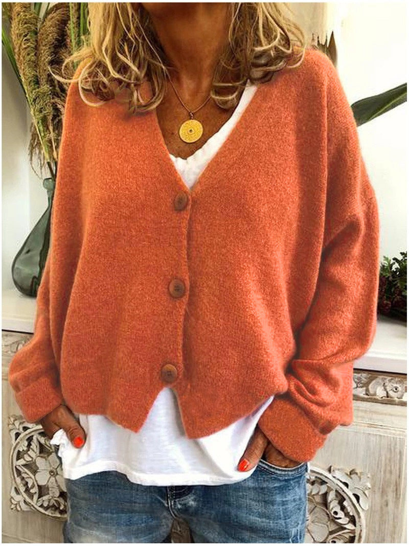 Cardigan tricoté élégant de Danoir Paris, modèle Scarlett en orange, porté avec manches longues et finition raffinée.