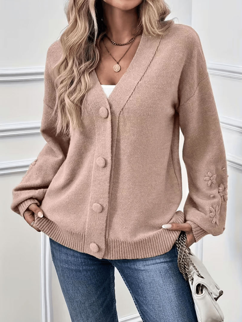 Cardigan classique élégant Hélène de Danoir Paris en rose pâle, porté avec manches longues et coupe ajustée.