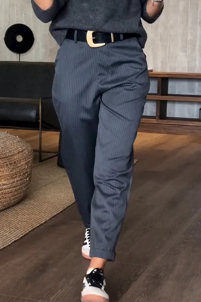 Pantalon élégant Mathilda de Danoir Paris en tissu bleu foncé, coupe polyvalente, porté avec une blouse blanche.