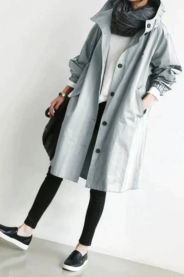 Manteau trench-coat élégant Danoir Paris Dorothee, déperlant gris clair, pour femme, porté sur un fond neutre.