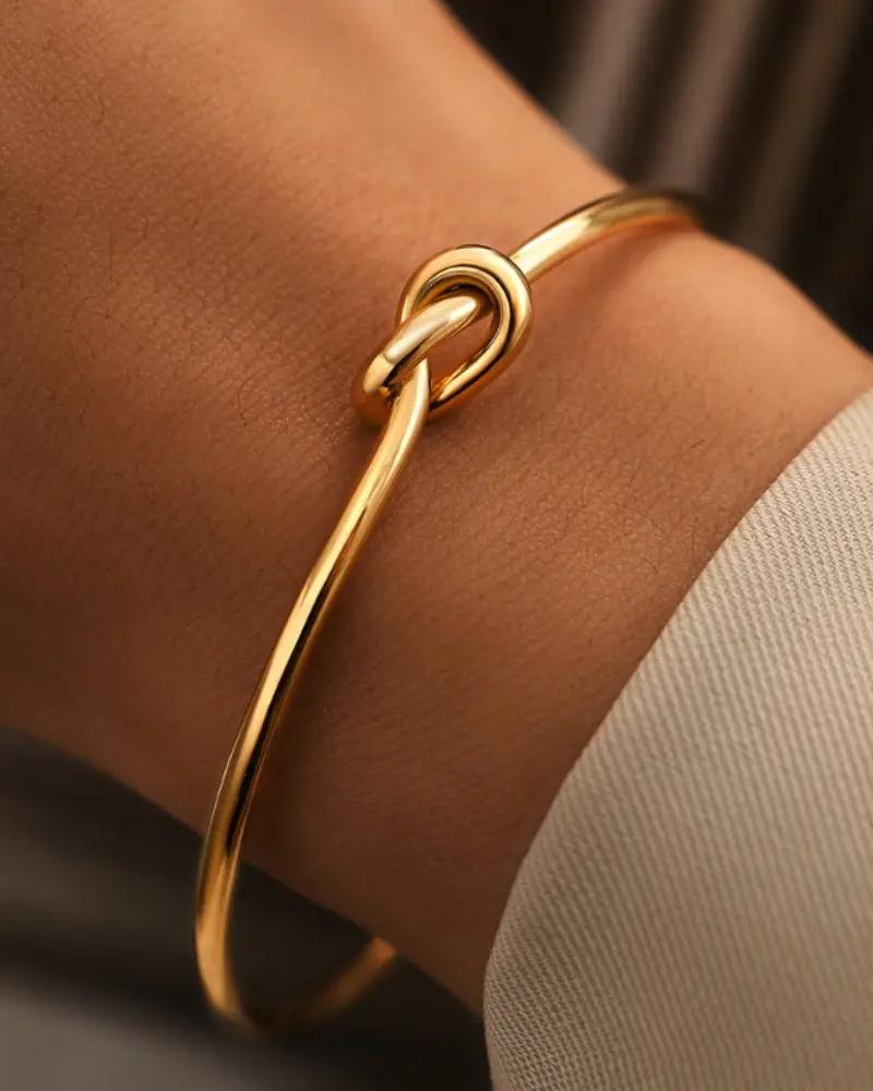 Bracelet en or Danoir Paris avec nœud d’éternité, finition élégante, porté sur le poignet, détail sophistiqué et moderne.