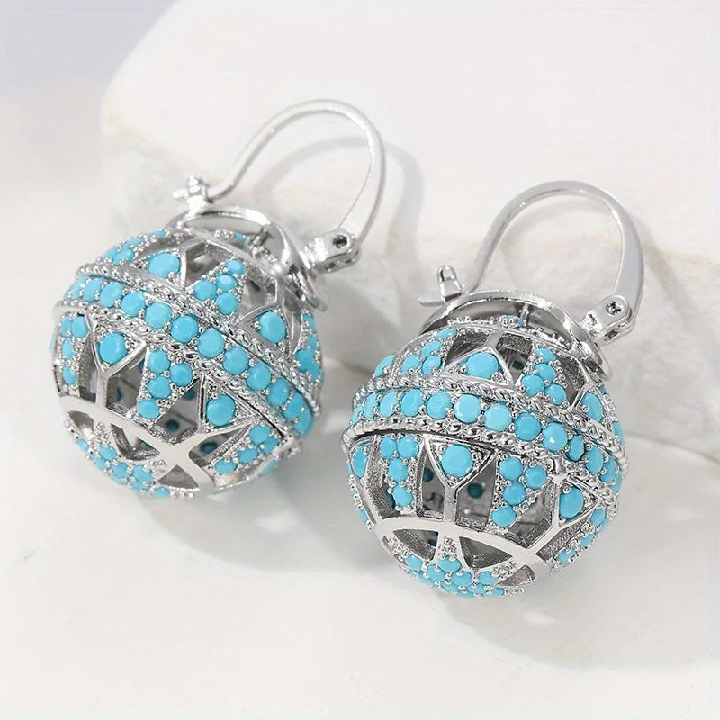 Boucles d'oreilles mandala turquoise doré de Danoir Paris, motif orné et élégant, en gros plan.