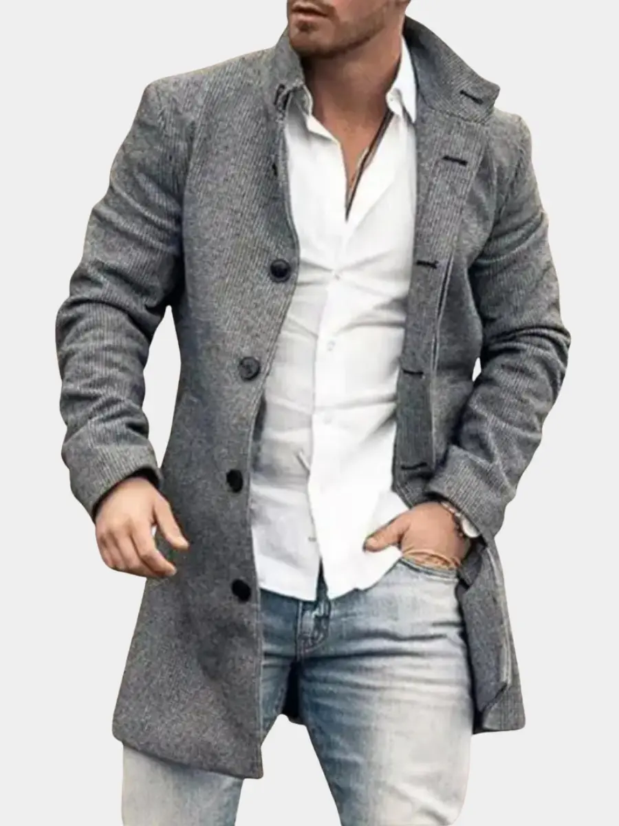 Manteau élégant pour homme Danoir Paris de couleur grise, style classique et coupe raffinée, porté en plein air.