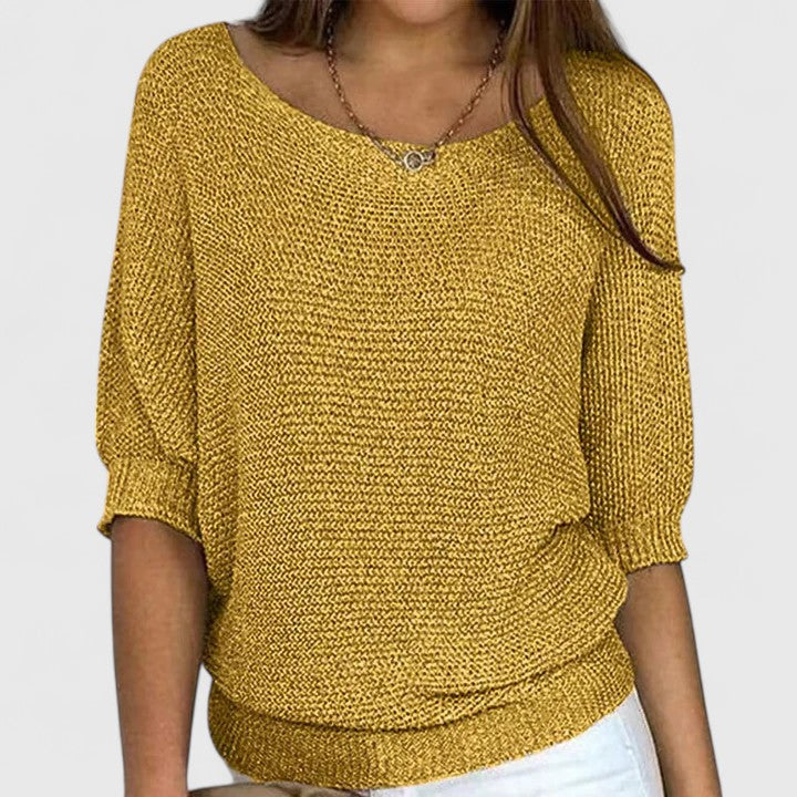Pull en maille gris Rachel de Danoir Paris, modèle sans effort, porté sur un fond neutre, mettant en valeur la texture douce du vêtement.