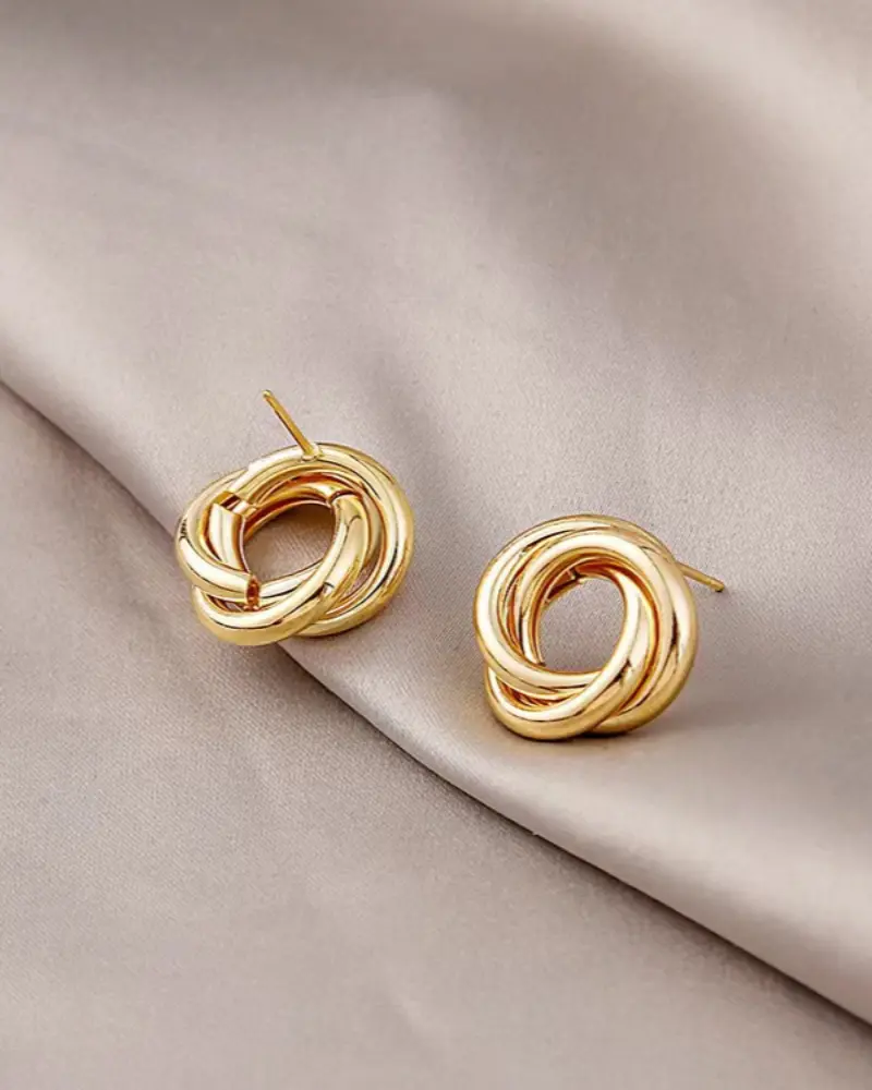Boucles d'oreilles dormeuses Aurelia Knot de Danoir Paris en métal avec nœud élégant, visibles en gros plan.