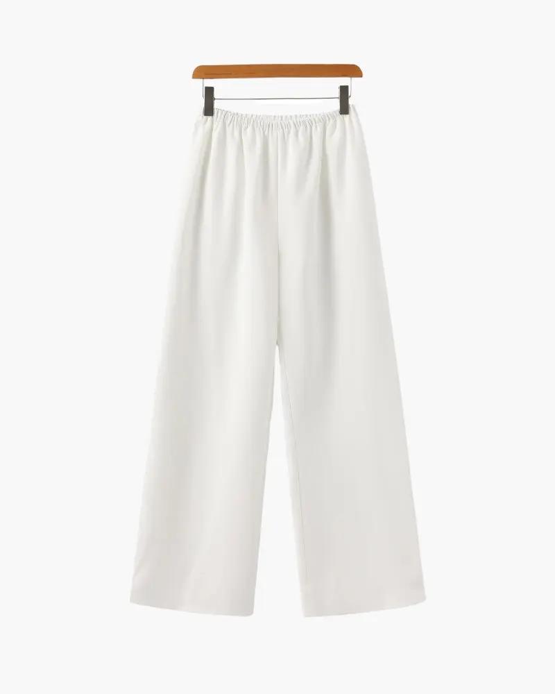 Pantalon Palais Danoir Paris en ivoire, coupe élégante, tissu léger, porté à la taille avec ceinture.