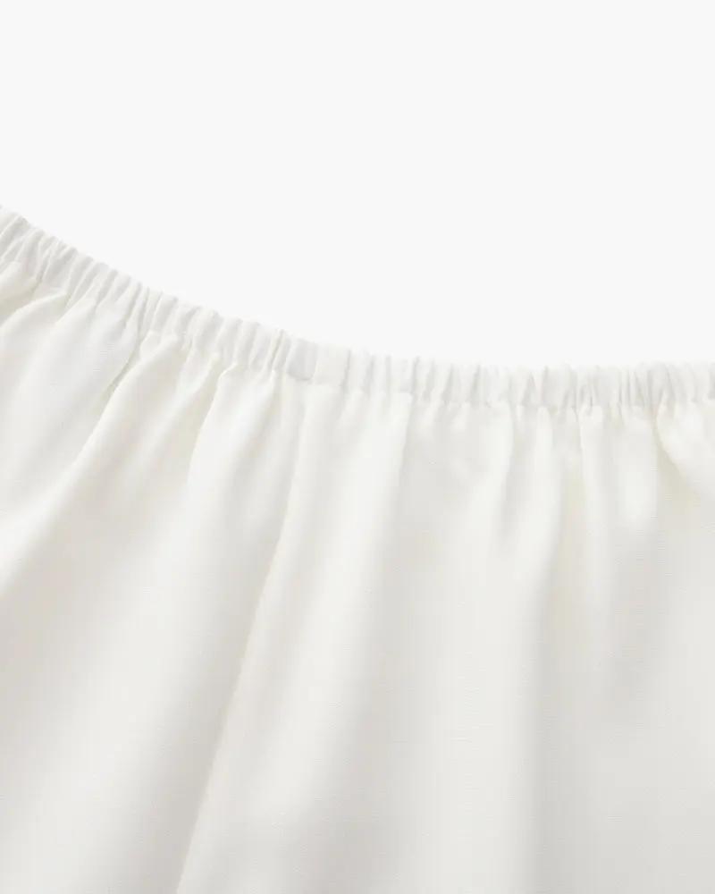 Pantalon Palais Danoir Paris en ivoire, coupe élégante, tissu léger, porté avec un haut blanc, détail de la taille visible.