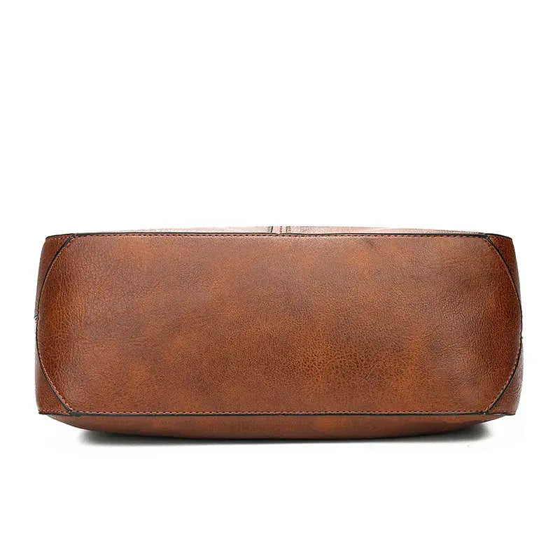 Sac élégant en cuir marron Romy de Danoir Paris, avec poignées et détails sophistiqués, sur fond neutre.