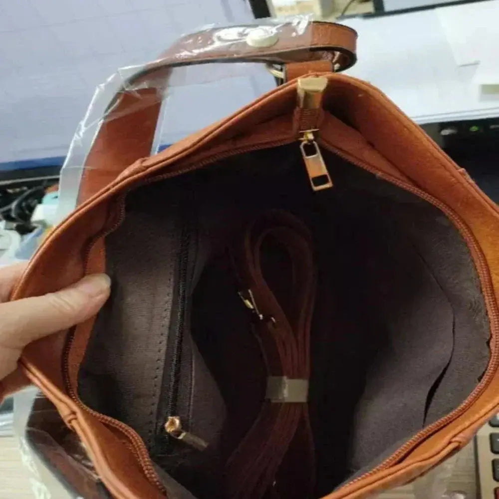 Sac à bandoulière vintage Danoir Paris Tessa en cuir marron, design classique et intemporel, avec poignées et détails élégants.