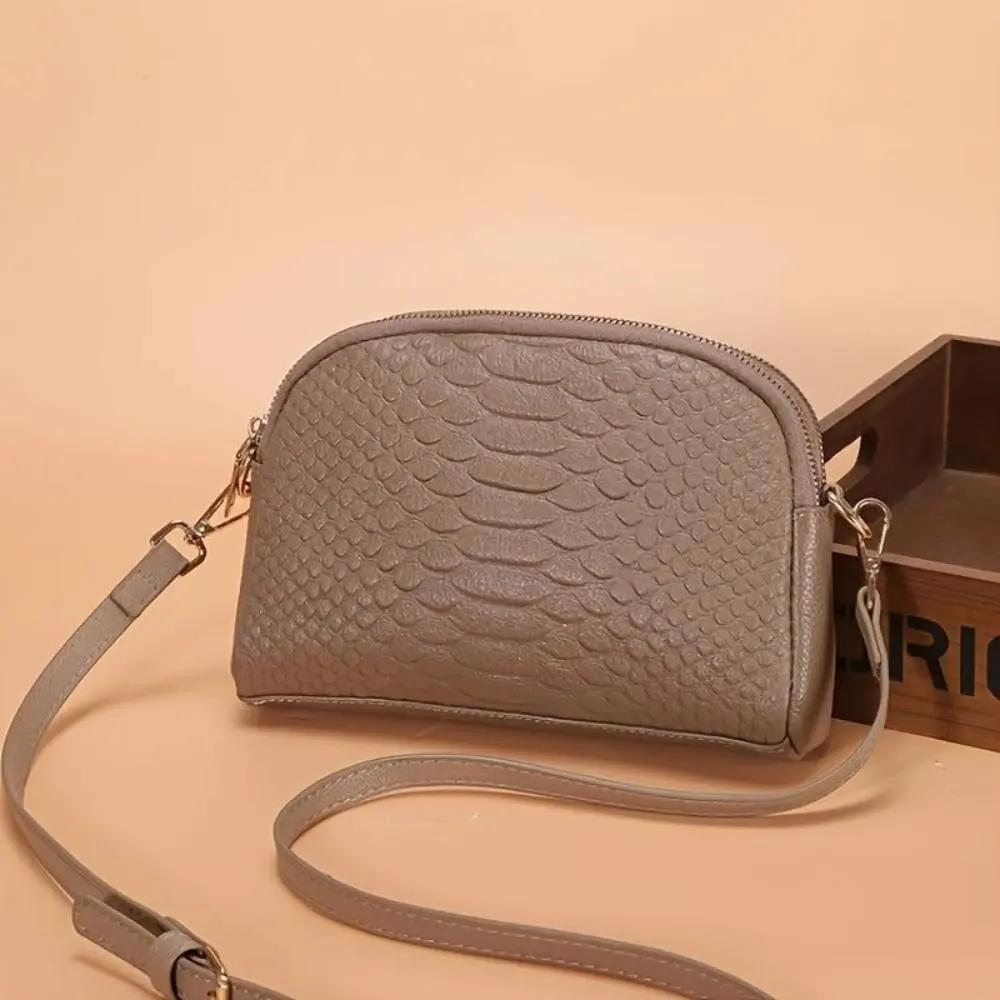 Mini sac à bandoulière Cora en simili cuir avec motif crocodile, de la marque Danoir Paris, en noir.