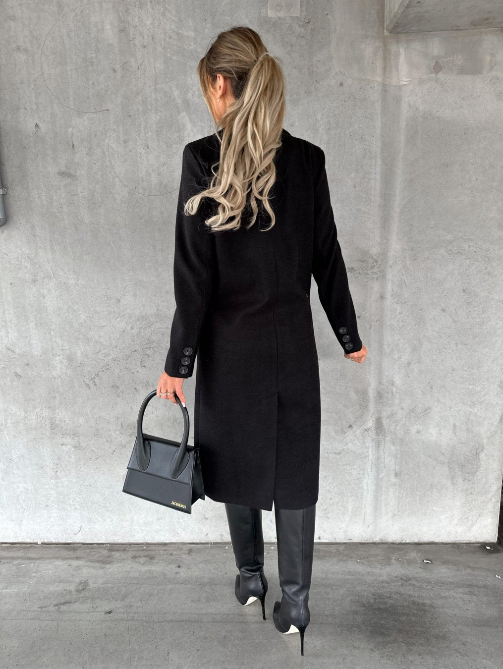 Manteau noir Danoir Paris Jolie, style intemporel, avec col élégant et coupe raffinée, porté en plein air.