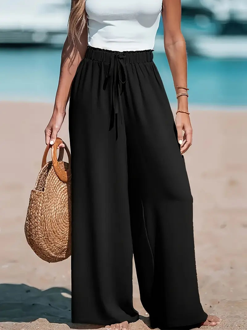 Pantalons taille haute élégants de la marque Danoir Paris, en noir, portés avec un style sophistiqué et moderne.