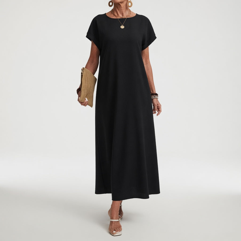 Robe longue élégante et minimaliste Margaux™ de Danoir Paris, noire, portée avec décolleté sobre, tissu fluide et coupe sophistiquée.