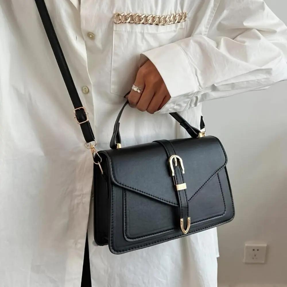 Sac à bandoulière noir Danoir Paris Tessa, élégant et minimaliste, avec poignée en cuir et design épuré.