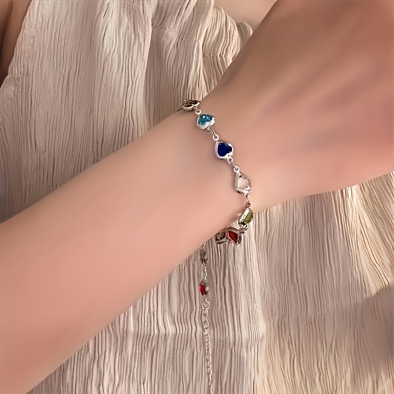 Bracelet unique en forme de cœur de Danoir Paris, en métal argenté avec détails élégants, porté au poignet.