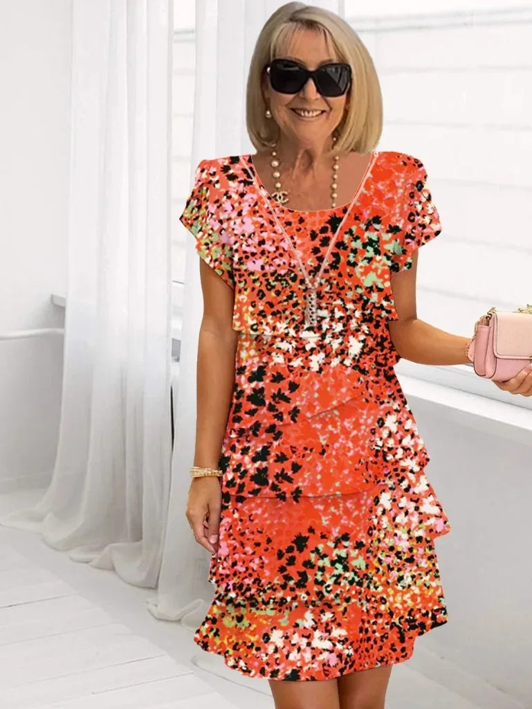 Robe élégance fluide à volants Danoir Paris Brigitte en tissu orange rouge, longueur courte et style sophistiqué.