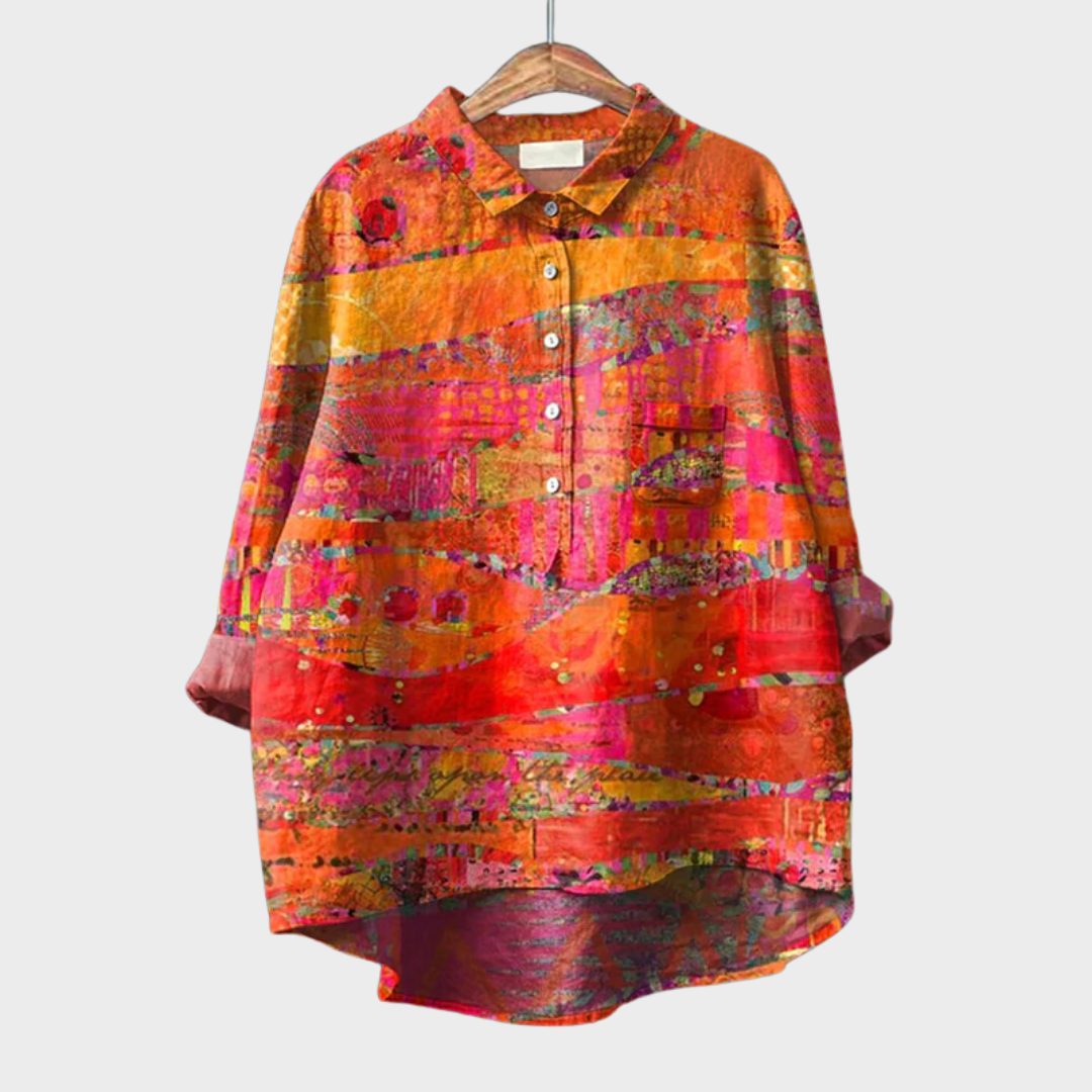 Blouse artistique vibrante Philomène de Danoir Paris en tissu orange avec motifs colorés, portée décontractée.