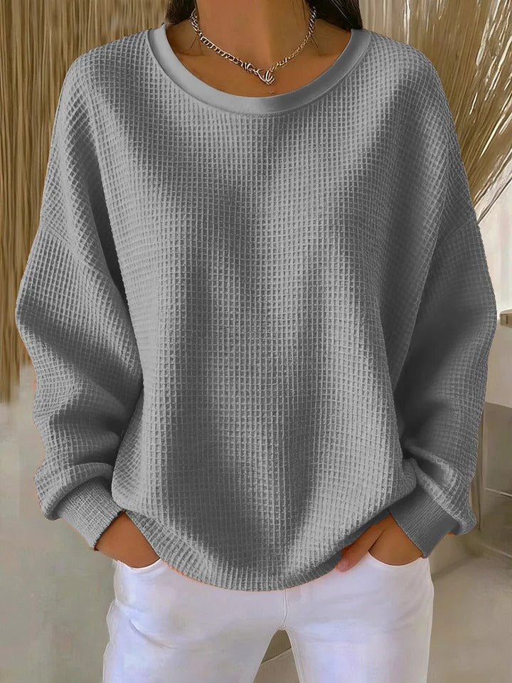 Pull classique rose Danoir Paris Lucille, en maille douce, avec col rond et manches longues, porté sur un fond neutre.