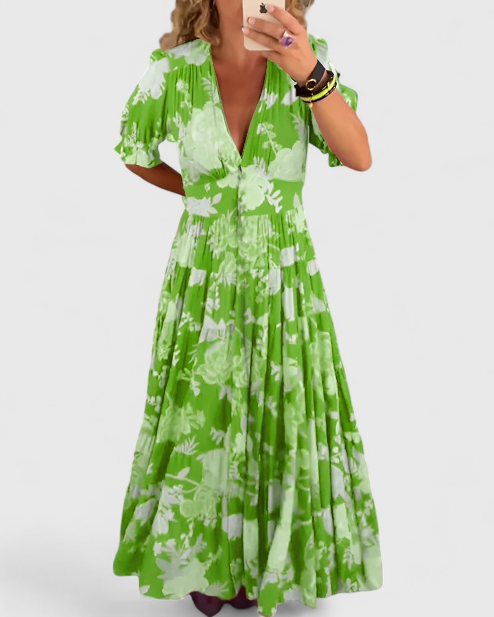 Robe fleurie Minelda de Danoir Paris avec col en V, tissu léger et motif floral rouge, portée élégamment.