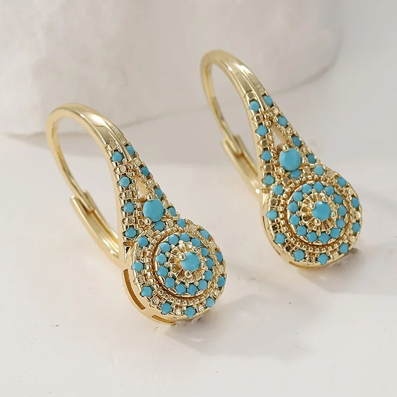 Boucles d'oreilles Danoir Paris Turquoise Gilded Bloom en turquoise et doré, élégantes et ornées de fleurs.