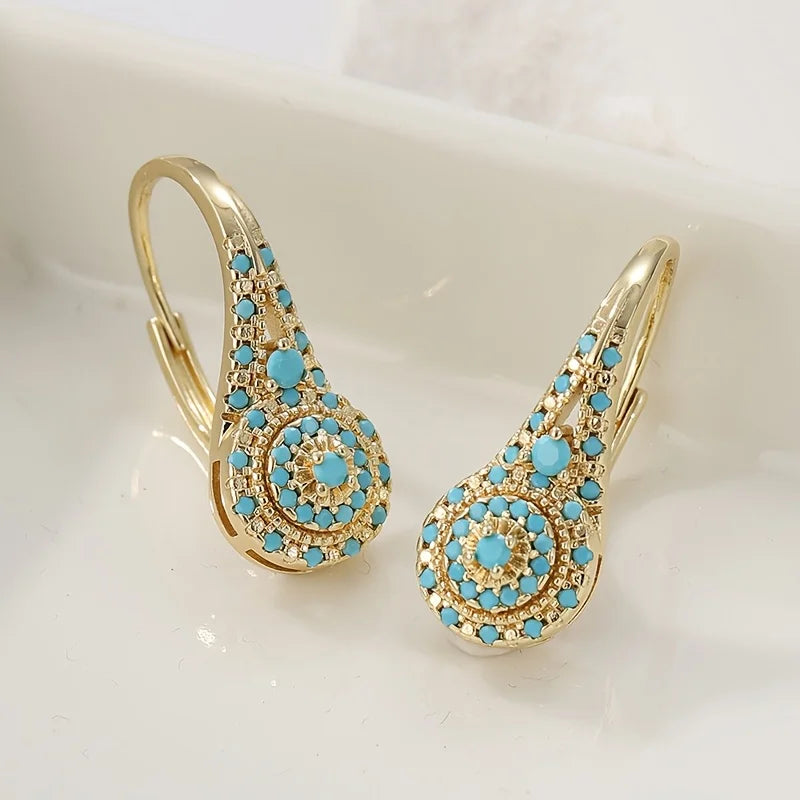 Boucles d'oreilles Danoir Paris Gilded Turquoise Bloom en turquoise ornée de détails dorés.