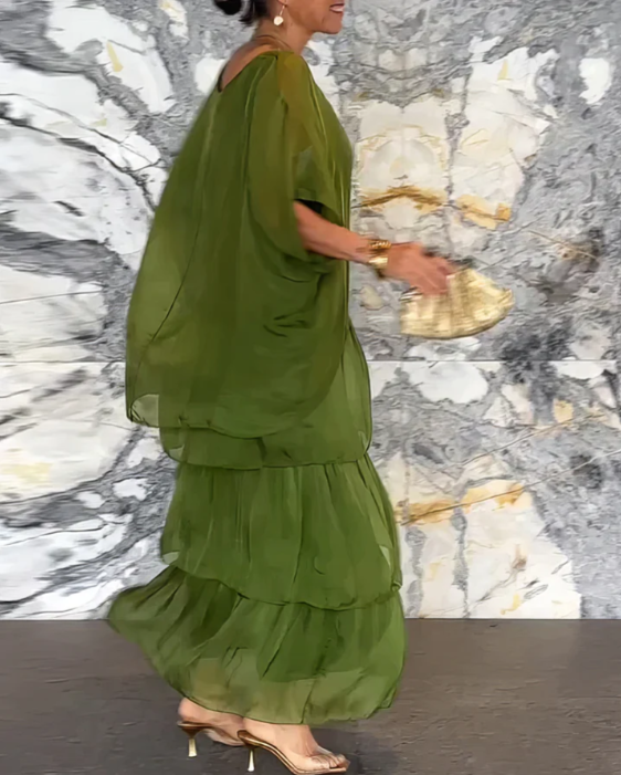 Robe longue fluide élégante Lara de Danoir Paris en tissu vert délavé, portée avec détails sophistiqués.