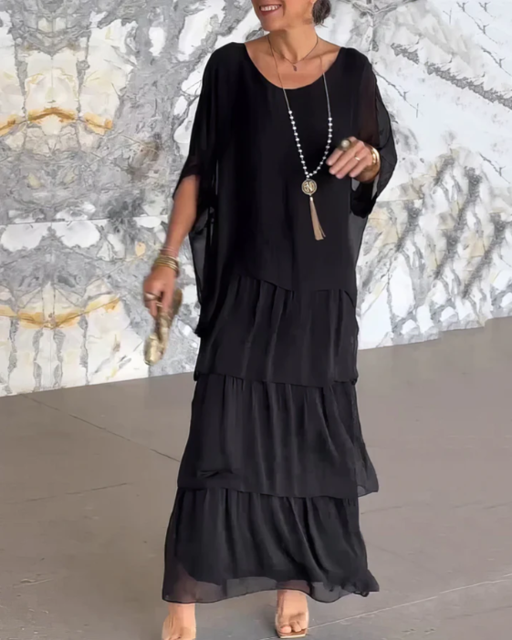 Robe longue fluide élégante Danoir Paris Lara en tissu vert délavé, porté avec détails subtils et coupe sophistiquée.