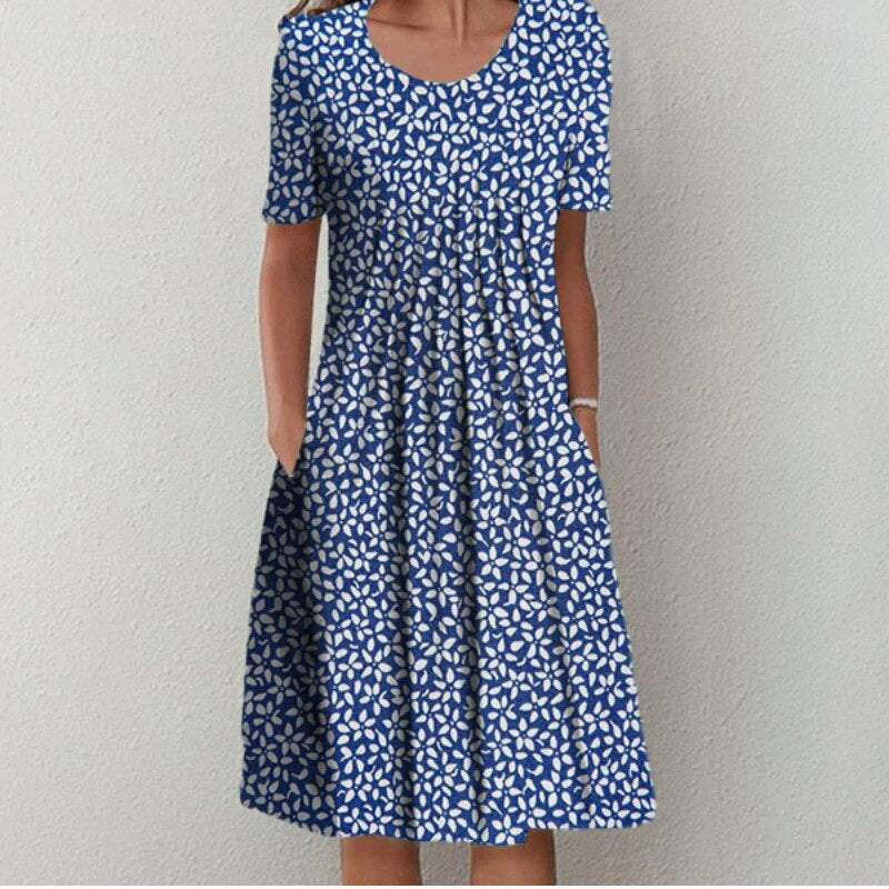Robe midi élégante pour femme Danoir Paris, en tissu léger blanc à fleurs multicolores, style aéré et sophistiqué.