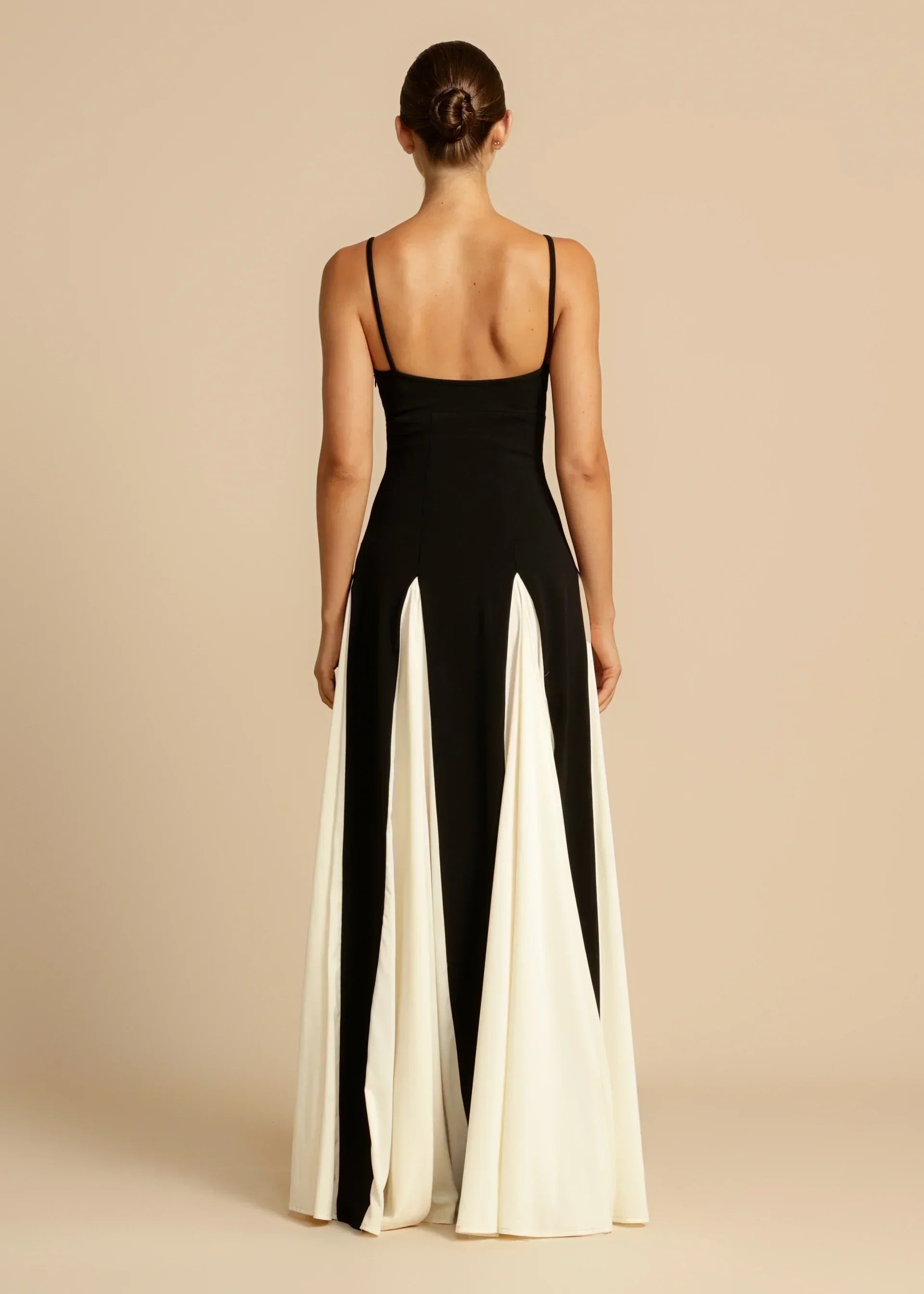 Robe longue élégante Sandra de Danoir Paris, tissu fluide, en coloris noir, portée avec décolleté stylé et manches longues.