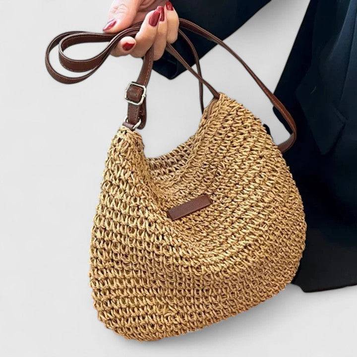 Sac élégant Kathy de Danoir Paris, en cuir noir avec poignées courbes et finition sophistiquée, posé sur une surface claire.