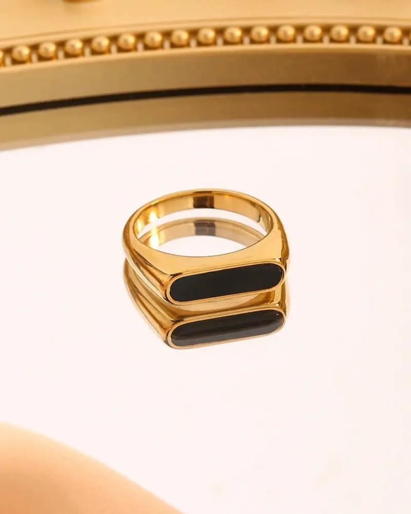Bague en obsidienne de la marque Old Money, finition lisse et brillante, portée sur un doigt.