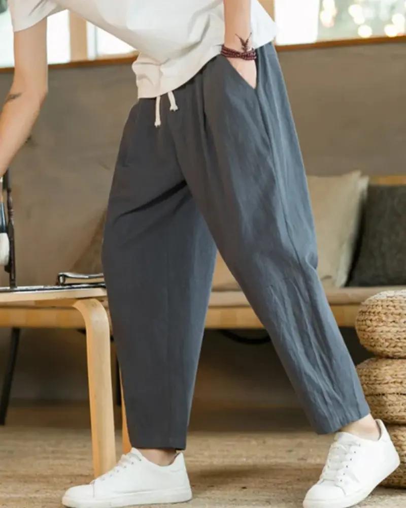 Pantalon en coton beige Old Money Cancun avec coupe décontractée et ceinture, porté sur un fond neutre.