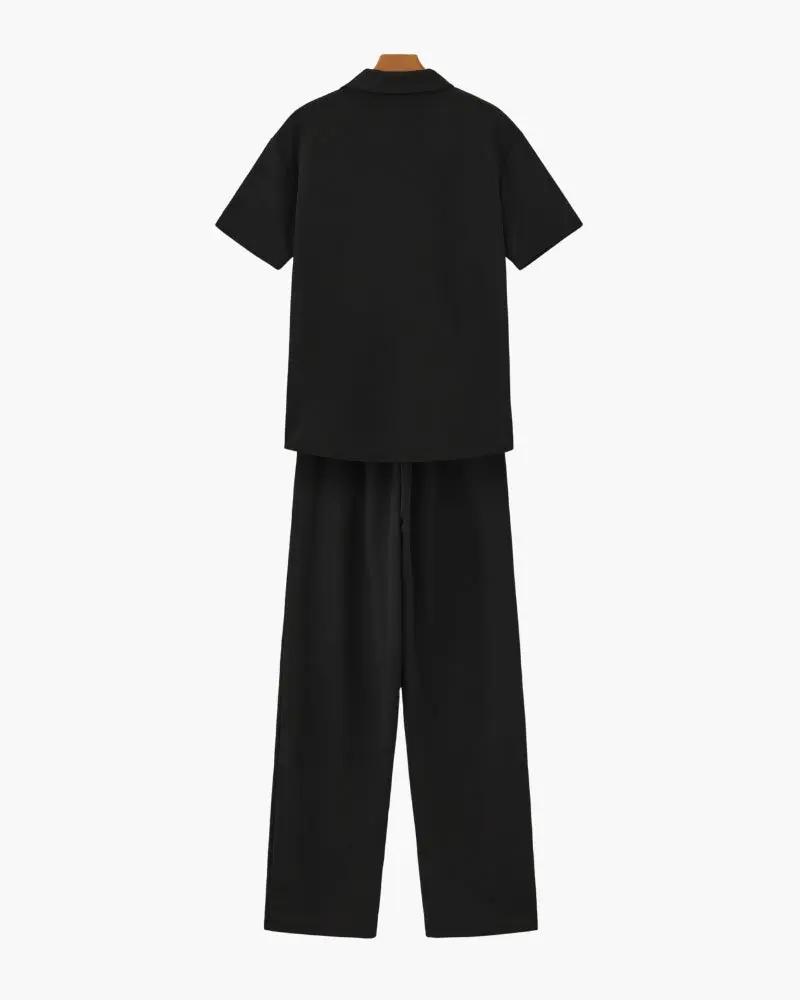 Ensemble polo en coton noir et pantalon de la marque Old Money, vue de haut avec détails du tissu et coupe décontractée.