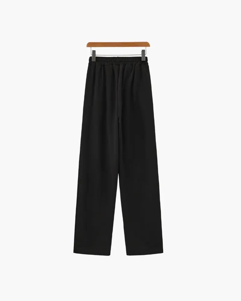 Ensemble polo en coton noir et pantalon de la marque Old Money, vue de face sur fond neutre.