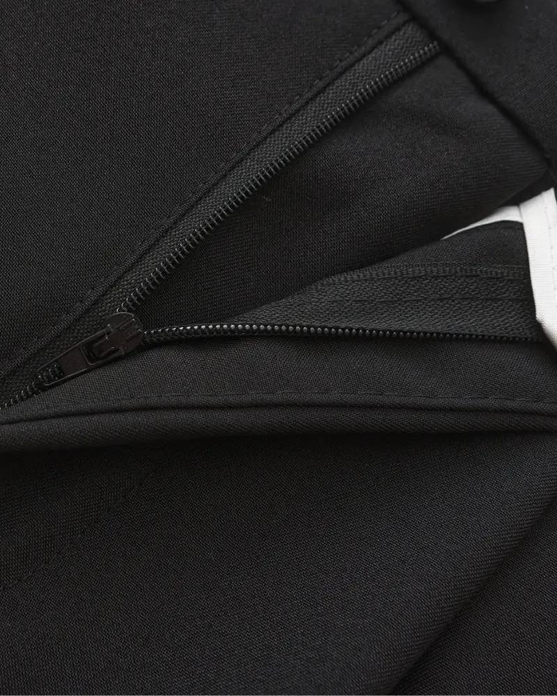 Pantalon Paris large taille de la marque Old Money, coupe ample, tissu noir élégant, porté avec chemise blanche.