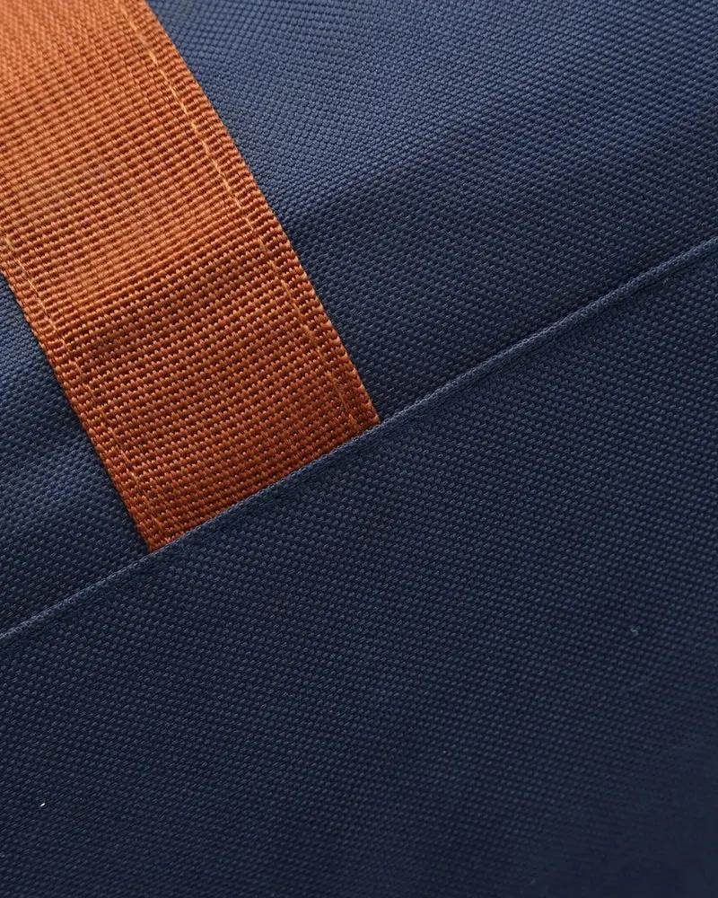 Sac de voyage Old Money Nova Duffle en bleu, vue de face avec poignées en cuir et fermeture éclair.